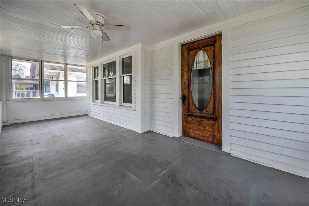 View of exterior entry with a ceiling fan