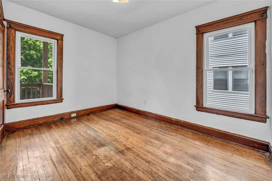 Unfurnished room featuring baseboards and hardwood / wood-style floors