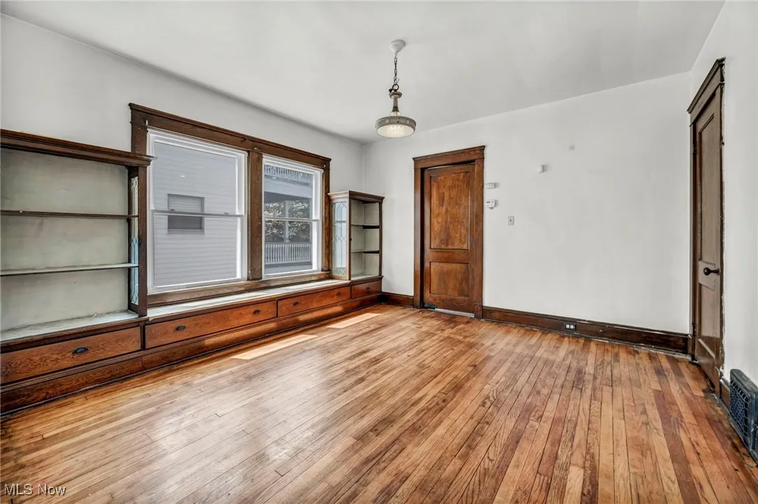Empty room featuring baseboards and hardwood / wood-style flooring