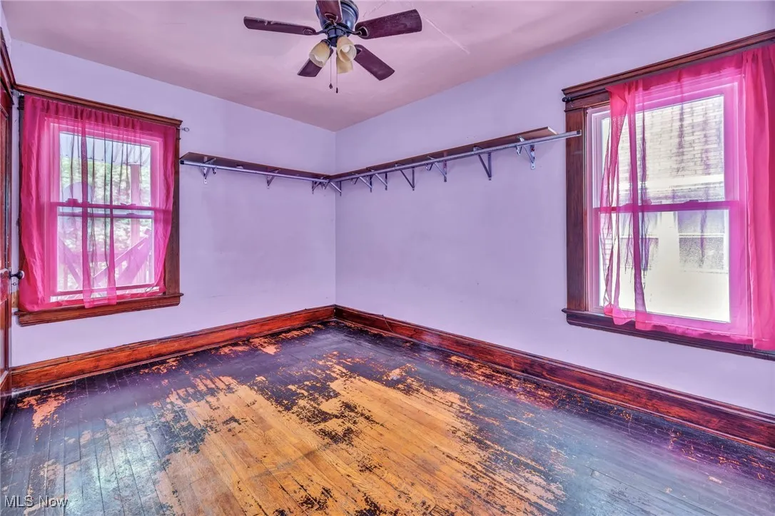 Empty room with baseboards, a ceiling fan, and hardwood / wood-style flooring