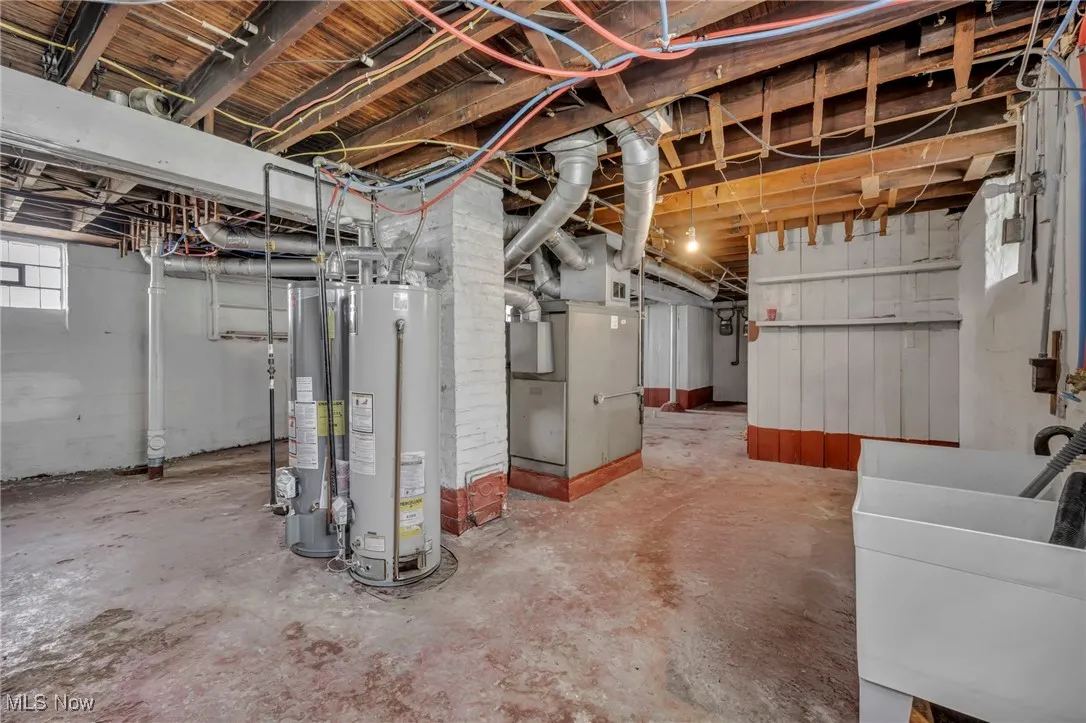Basement with heating unit, a sink, and gas water heater