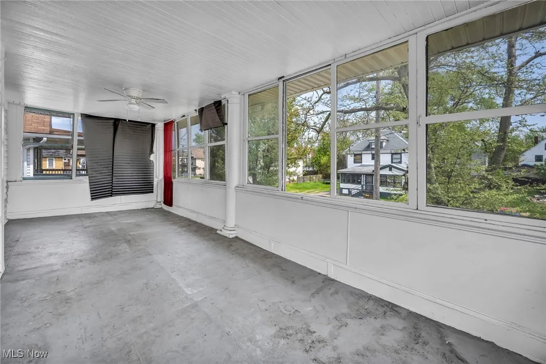 Unfurnished sunroom with ceiling fan