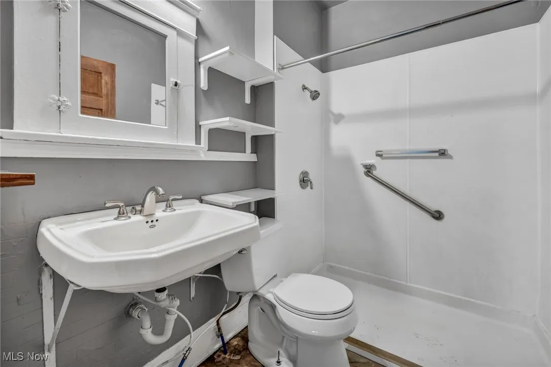Full bath with toilet and a shower stall