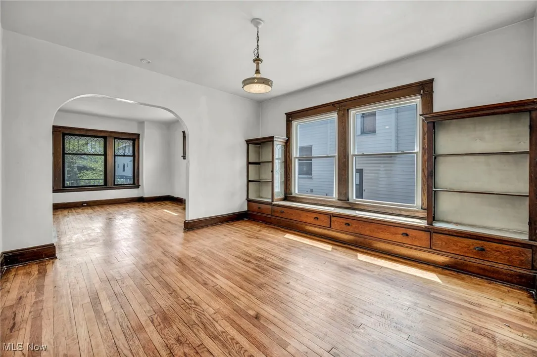 Spare room with arched walkways, baseboards, and hardwood / wood-style flooring