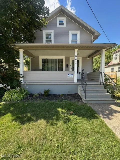 View of front facade featuring covered porch and a front lawn
