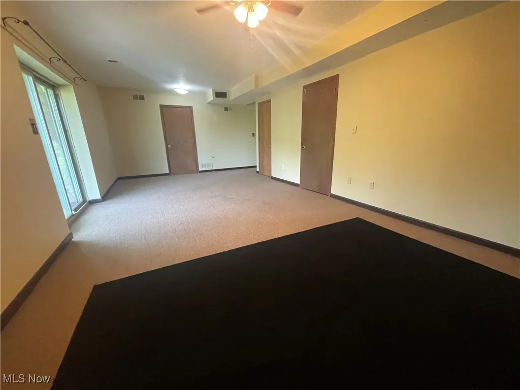 Great Room With Walk Out Patio Door featuring baseboards and a fireplace