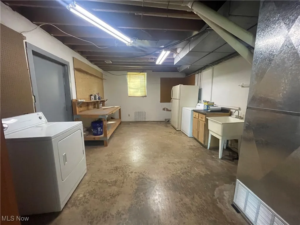 Utility Room area with freestanding refrigerator and washer / clothes dryer