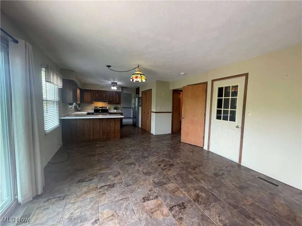 Kitchen featuring stainless steel appliances, visible vents, a sink, and a peninsula