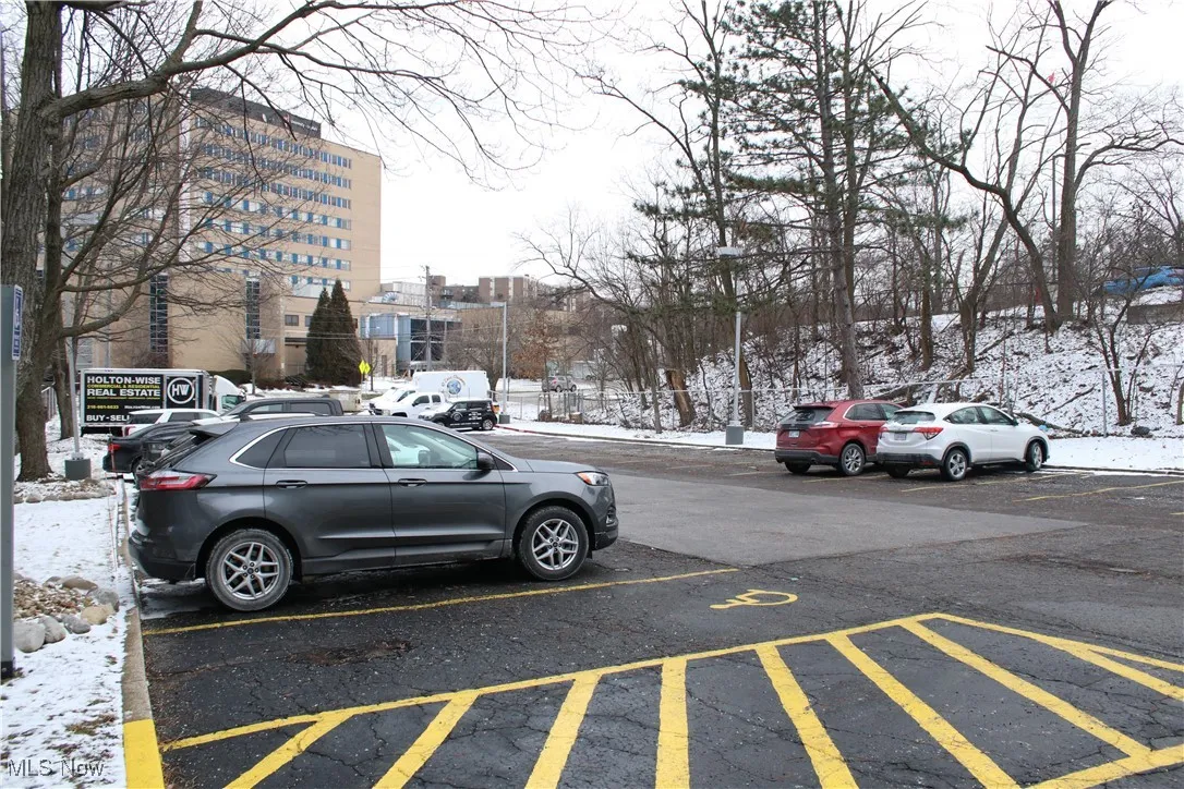 Snow covered parking area featuring uncovered parking