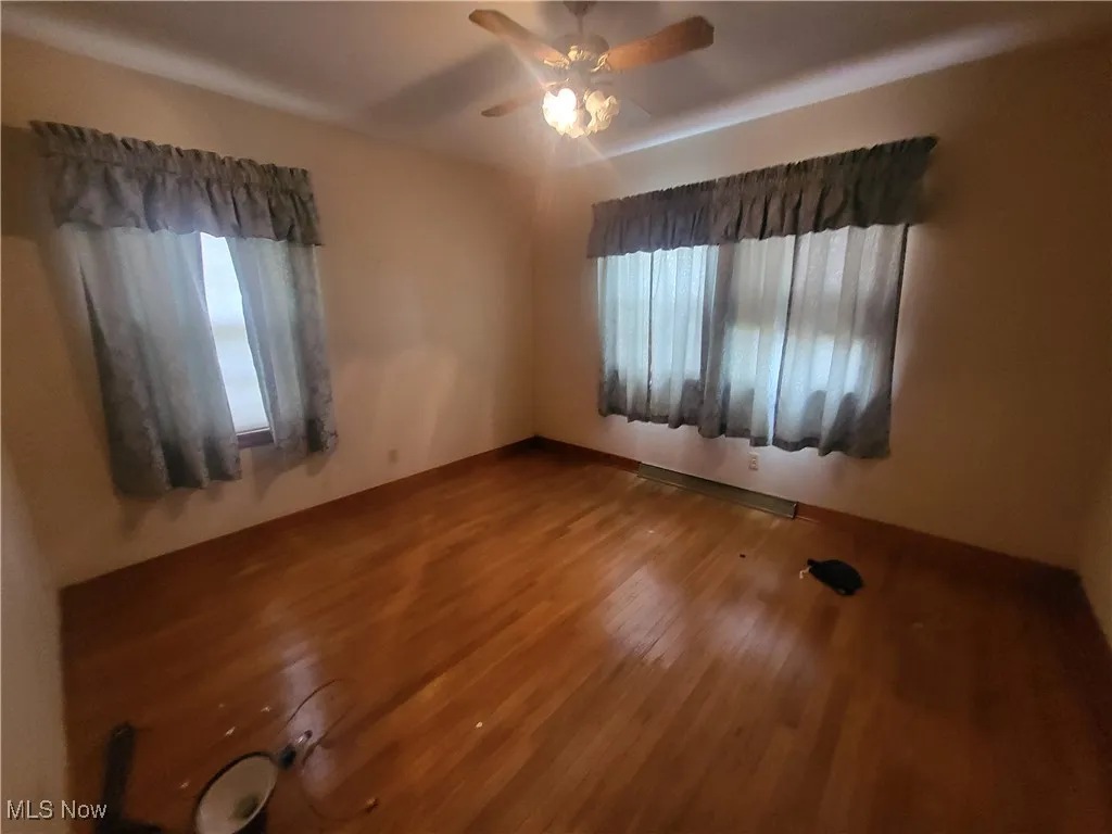 Unfurnished room featuring a ceiling fan and wood finished floors