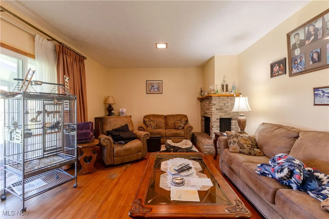 Living area featuring light wood-style floors and a brick fireplace