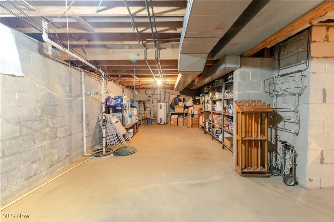 Unfinished below grade area featuring water heater