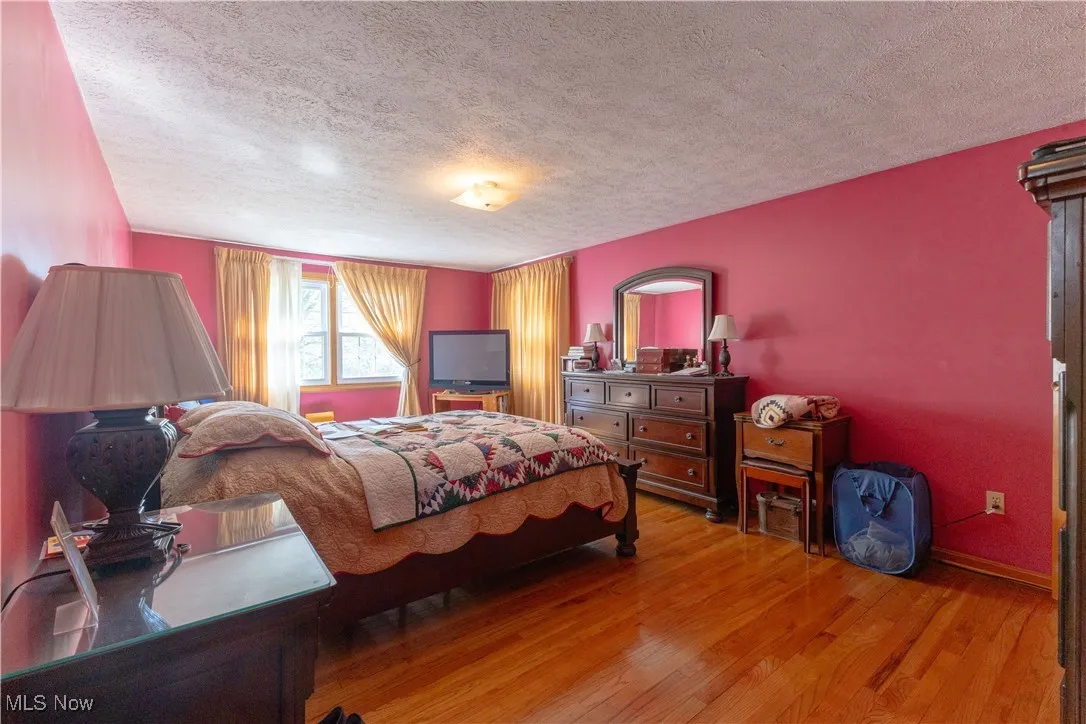 Bedroom featuring a textured ceiling and wood finished floors