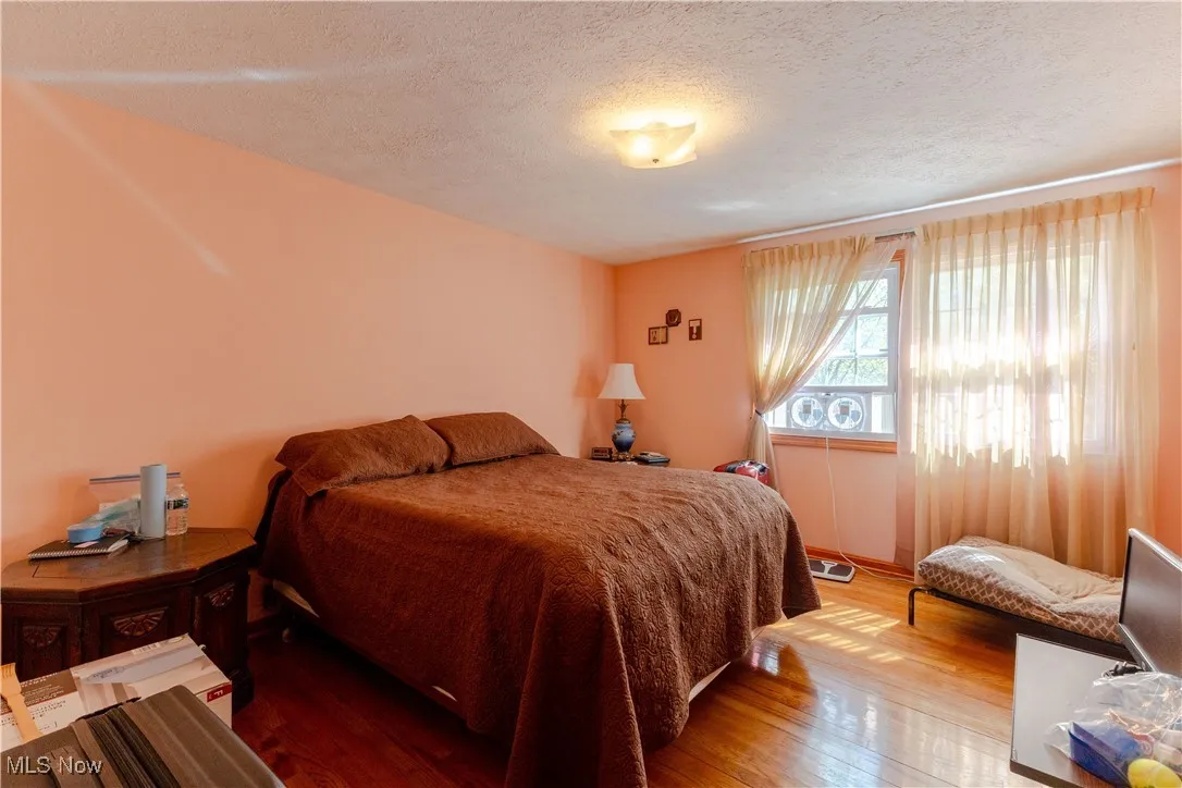 Bedroom featuring a textured ceiling and wood finished floors