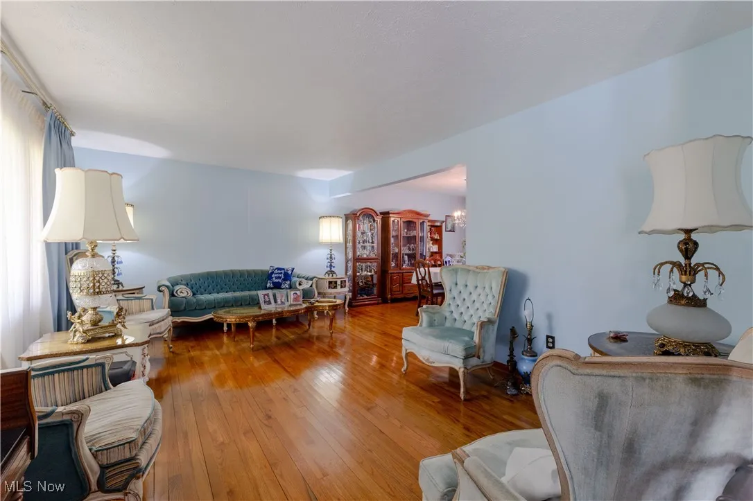Living room with wood-type flooring and a notable chandelier