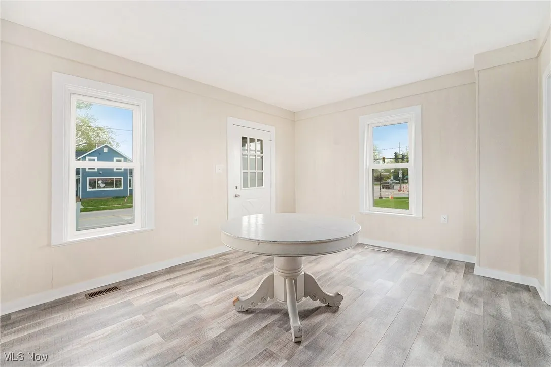 Unfurnished dining area with visible vents, baseboards, and wood finished floors