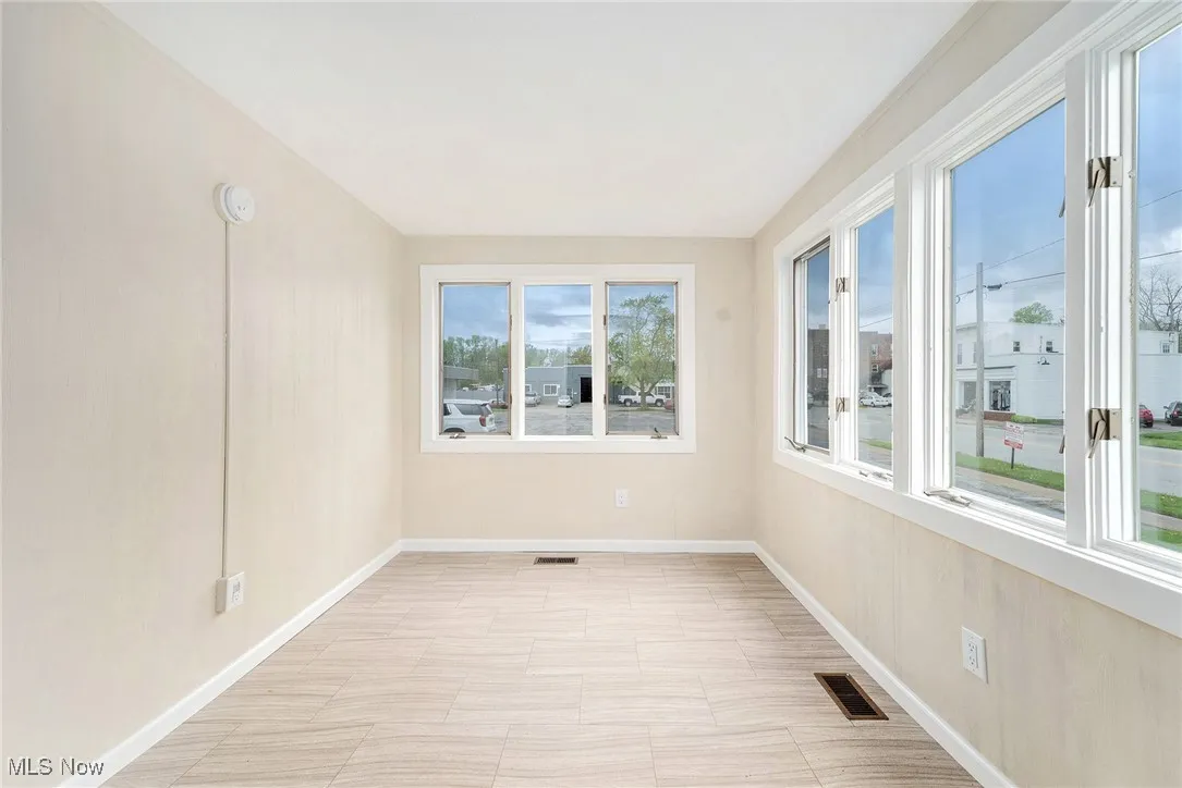Empty room with a healthy amount of sunlight, baseboards, and visible vents