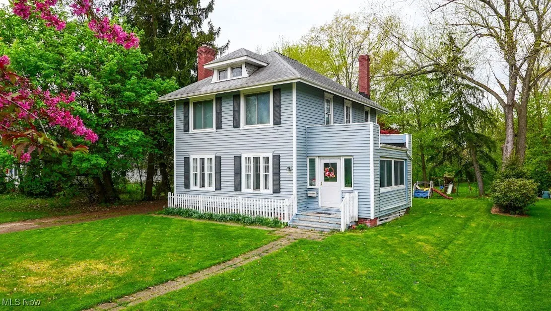 Rear view of house featuring a yard and a chimney