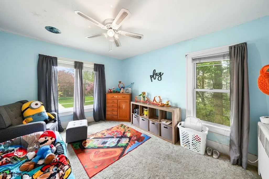 Recreation room with light carpet, a ceiling fan, and a wealth of natural light
