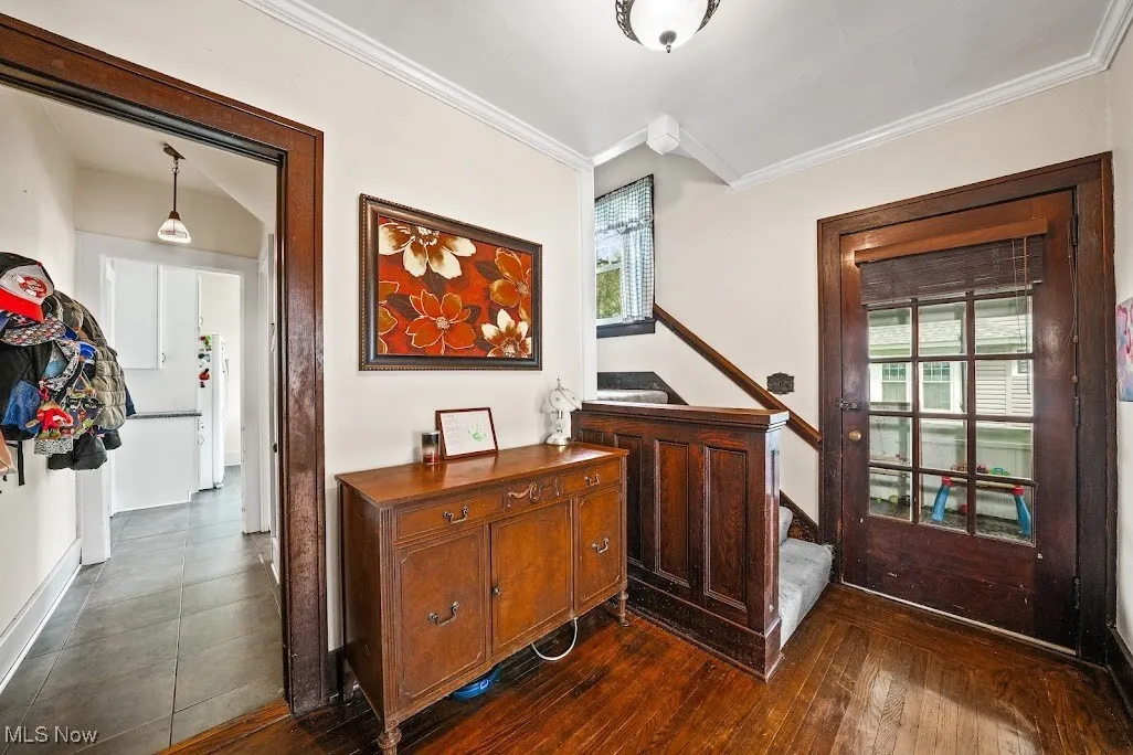Corridor featuring crown molding, stairs, and baseboards