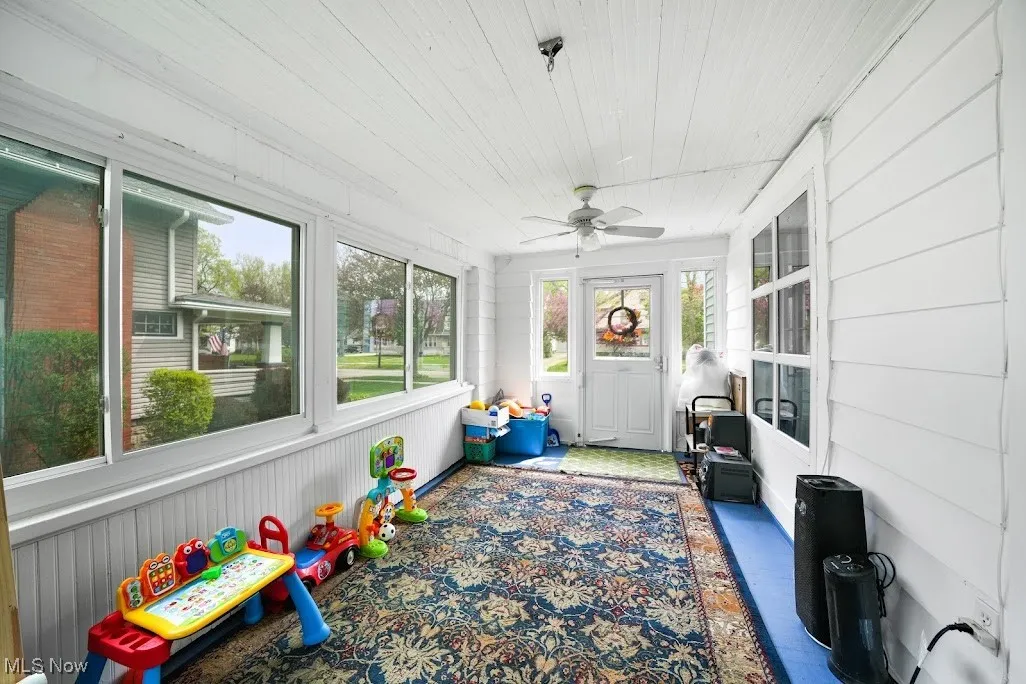 Sunroom featuring a ceiling fan