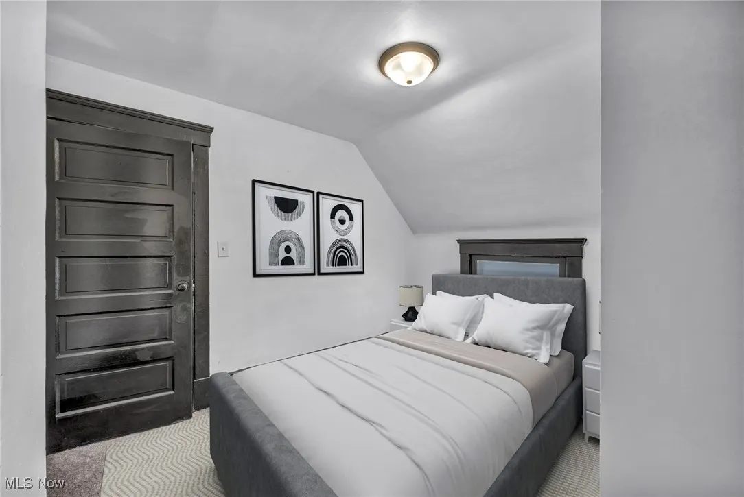 Bedroom featuring lofted ceiling and carpet flooring