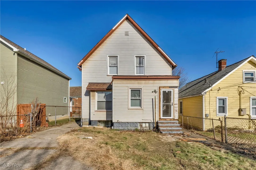 Back of property featuring entry steps and fence
