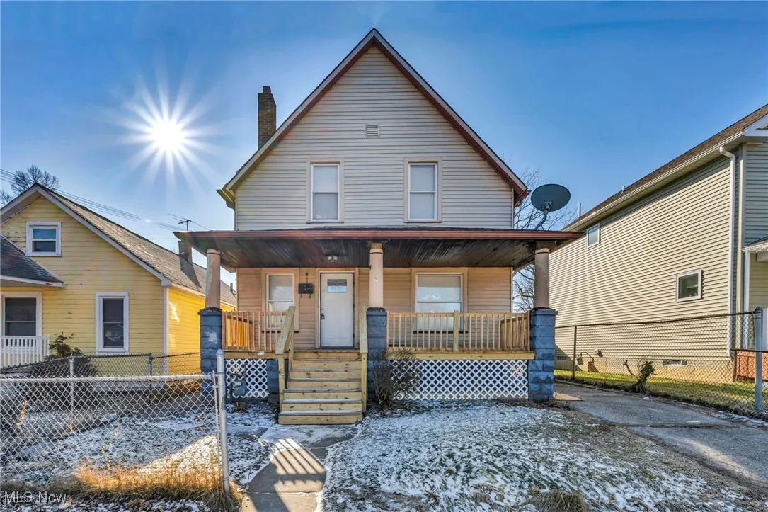 View of front facade featuring fence and a porch