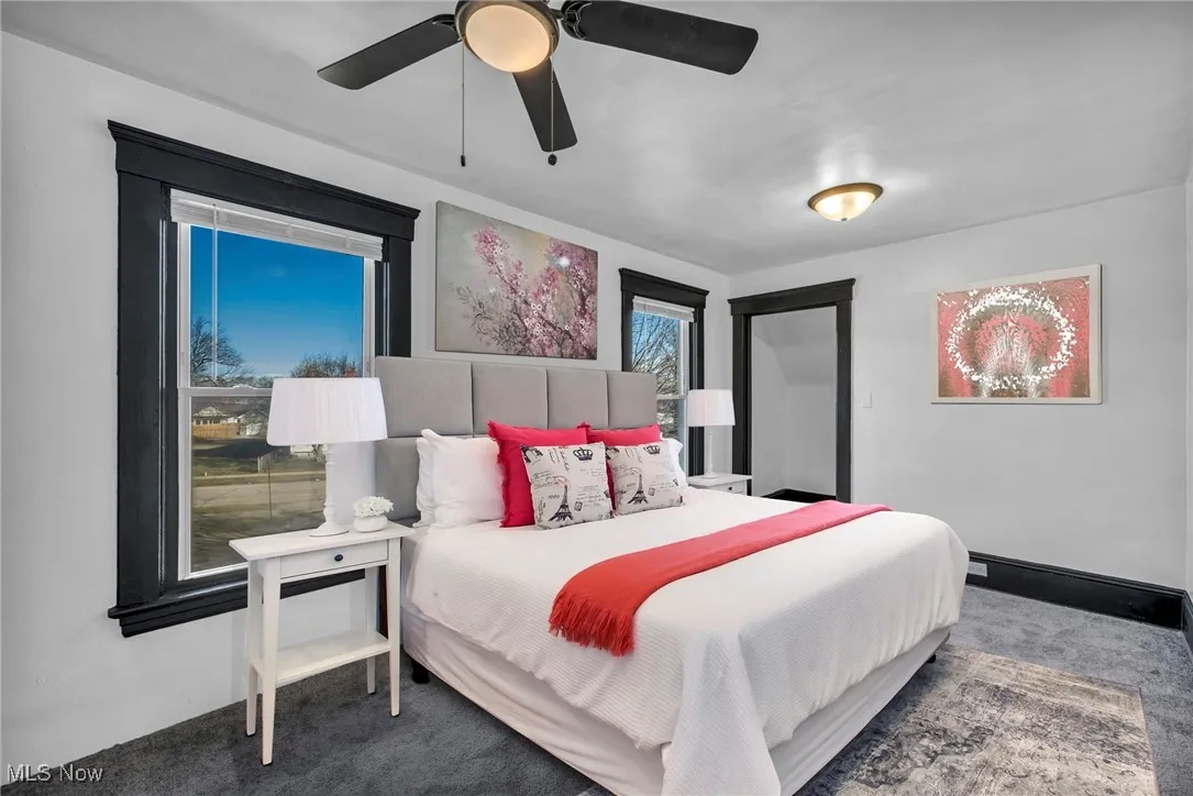Carpeted bedroom with a ceiling fan