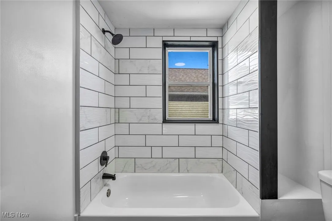 Bathroom featuring tub / shower combination and toilet