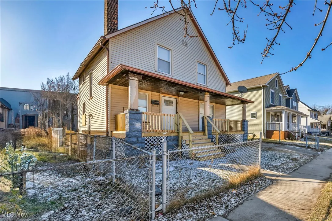 View of front of property with a porch, a chimney, a fenced front yard, and a gate