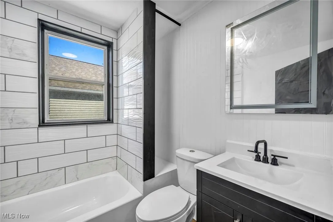 Bathroom featuring vanity, toilet, and shower / bathtub combination