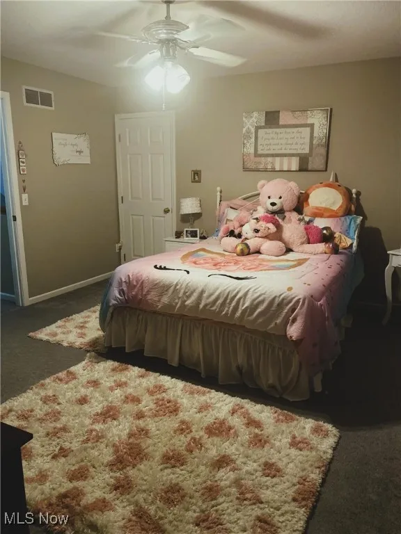 Carpeted bedroom with a ceiling fan and visible vents