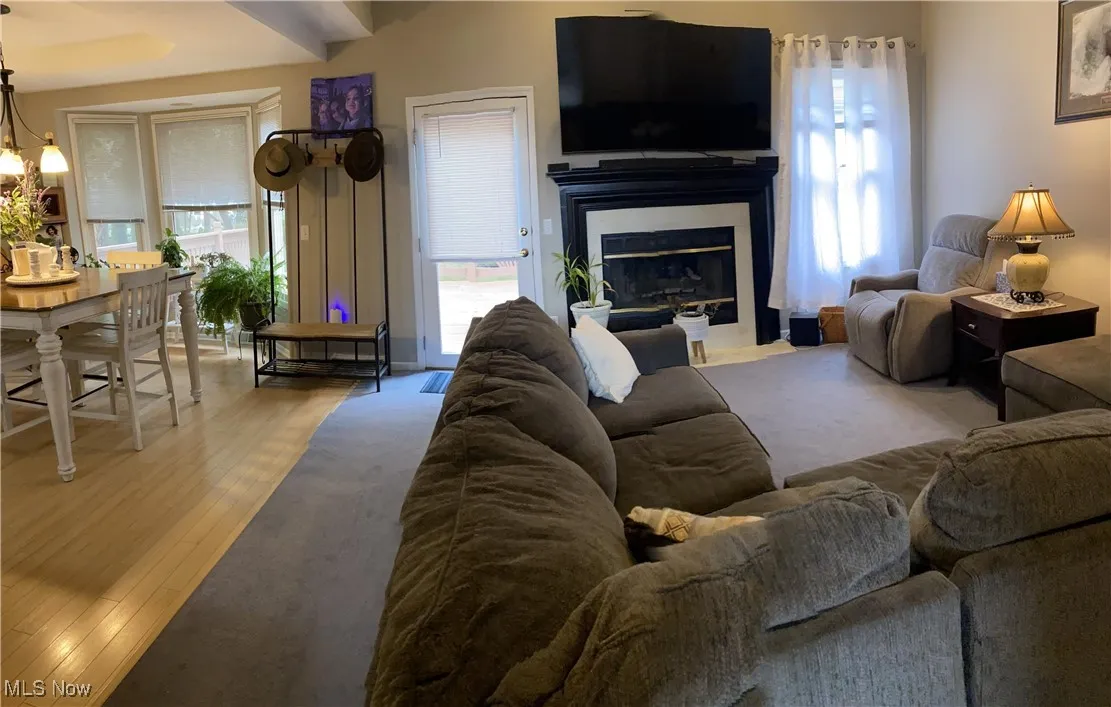Living area featuring a chandelier, a fireplace with flush hearth, and wood finished floors