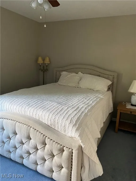 Carpeted bedroom featuring ceiling fan