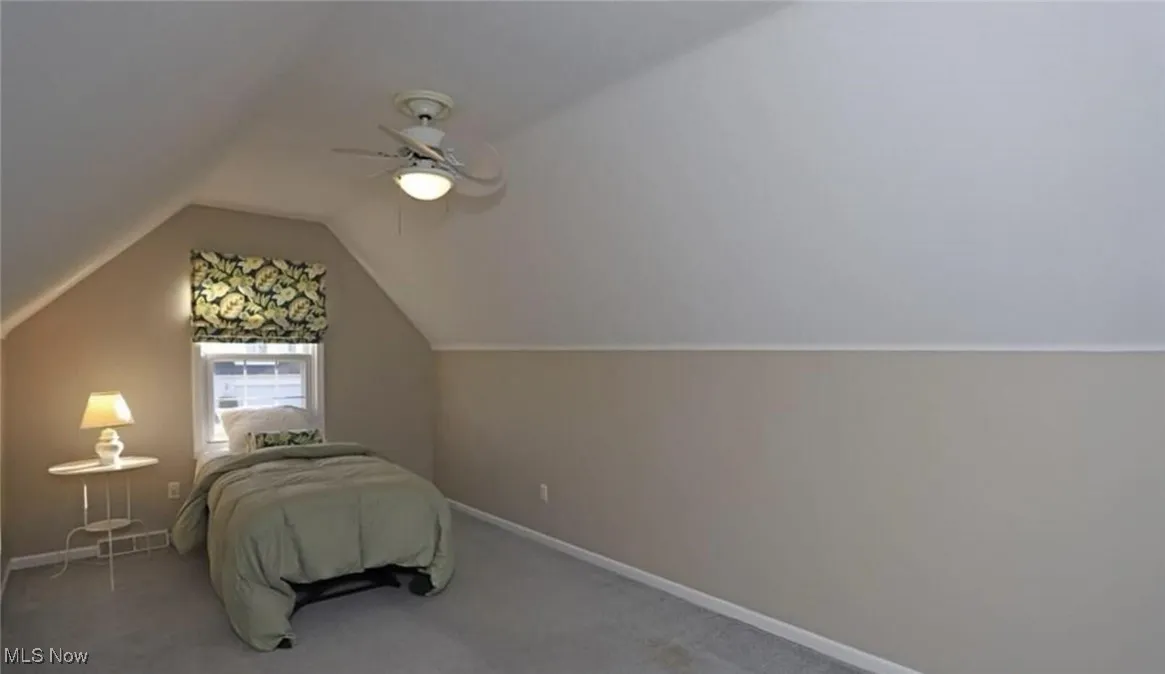 Unfurnished bedroom with baseboards, carpet flooring, ceiling fan, and vaulted ceiling