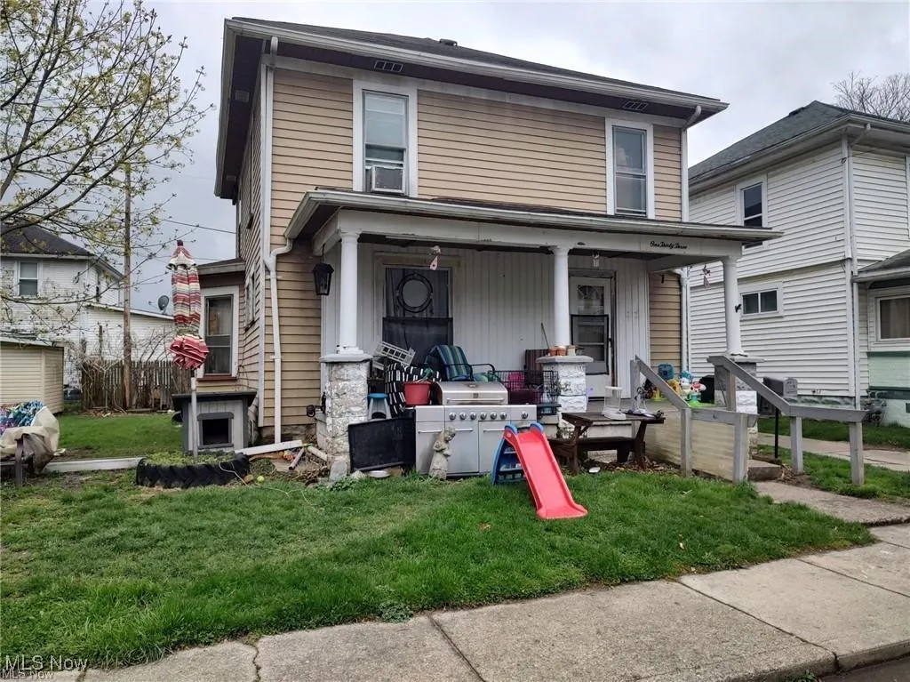 View of front of property with a porch and a front lawn