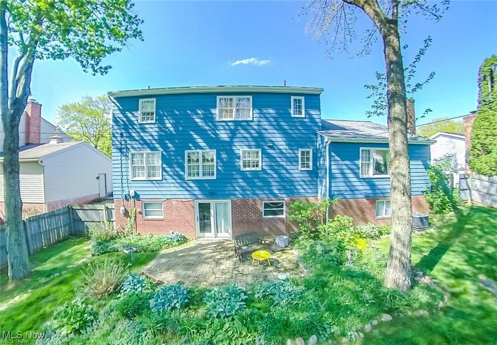 Rear view of house featuring a fenced backyard, a patio area, cooling unit, and a yard