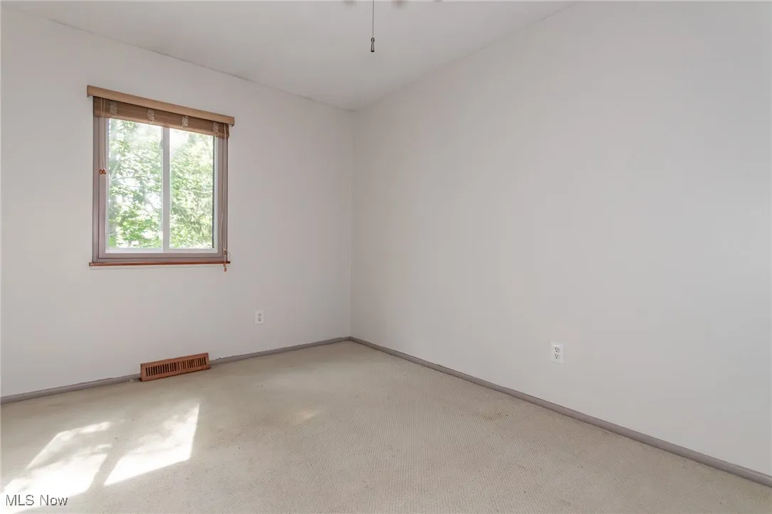 Unfurnished room with baseboards and light colored carpet