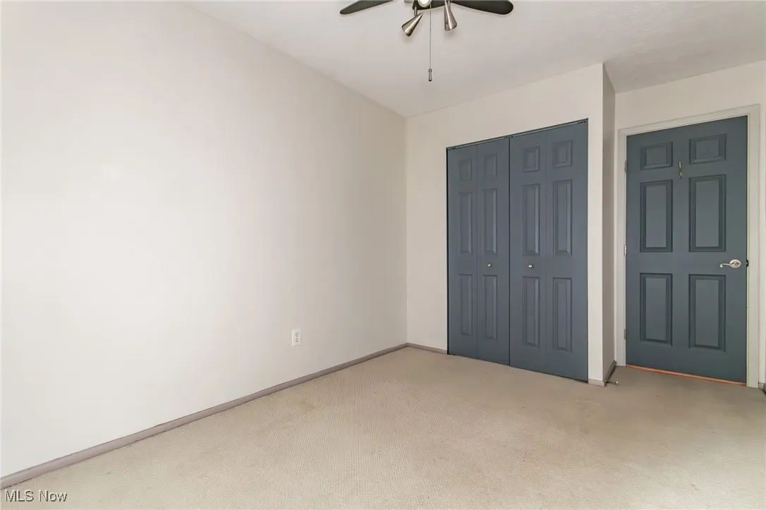 Unfurnished bedroom with carpet floors, a closet, and a ceiling fan