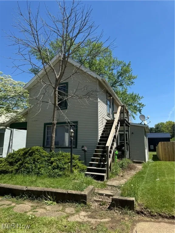 Front view of house featuring stairs and fence