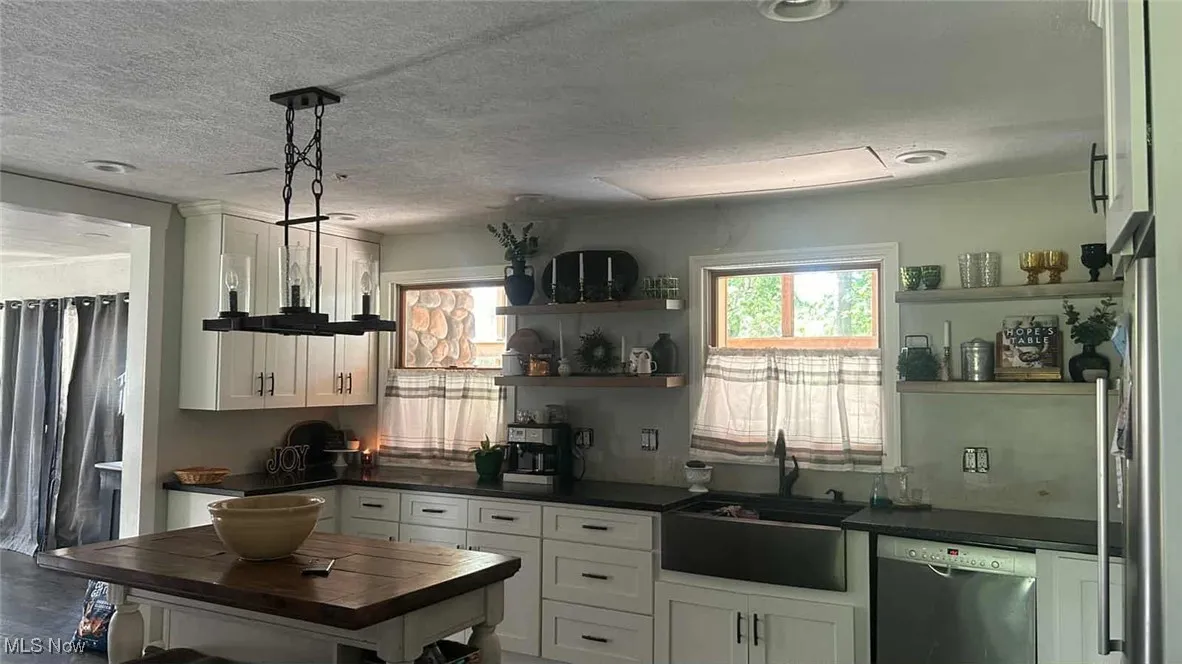 Updated farm style kitchen with White cabinets and island for preping