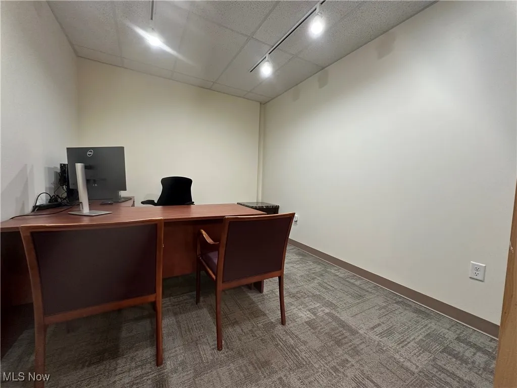 Carpeted office space featuring rail lighting