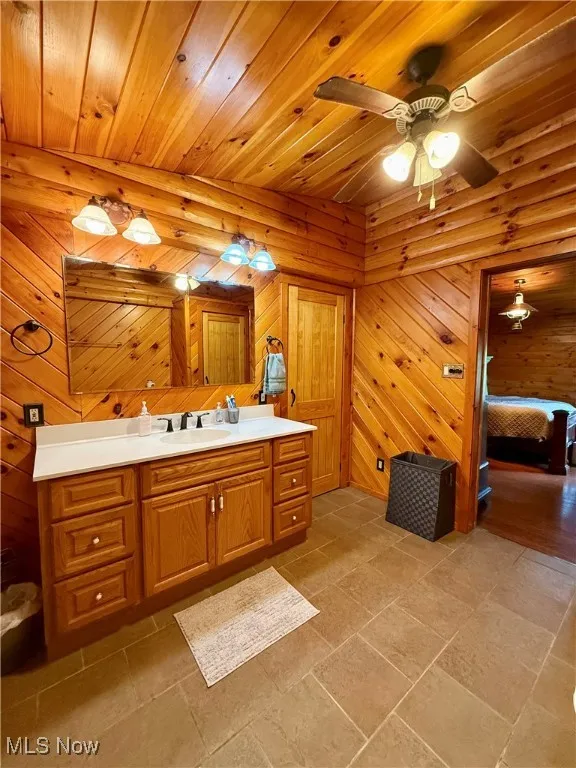 Bathroom with wood ceiling, a ceiling fan, and vanity