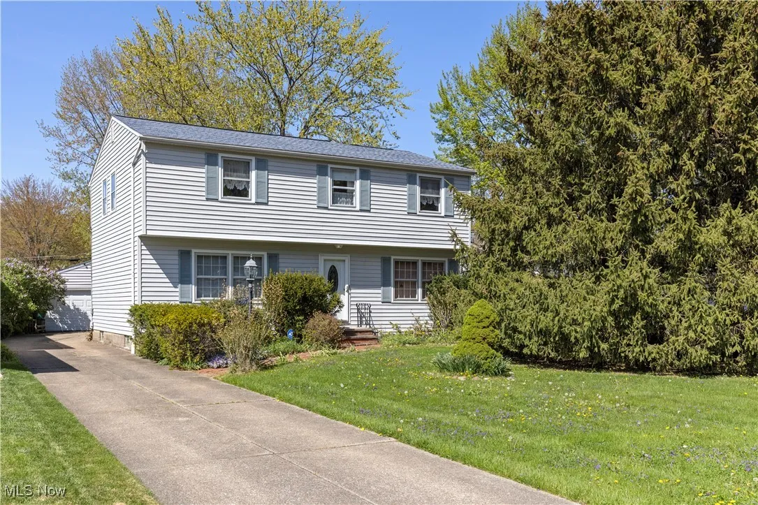 Colonial home featuring a detached garage, an outbuilding, and a front yard