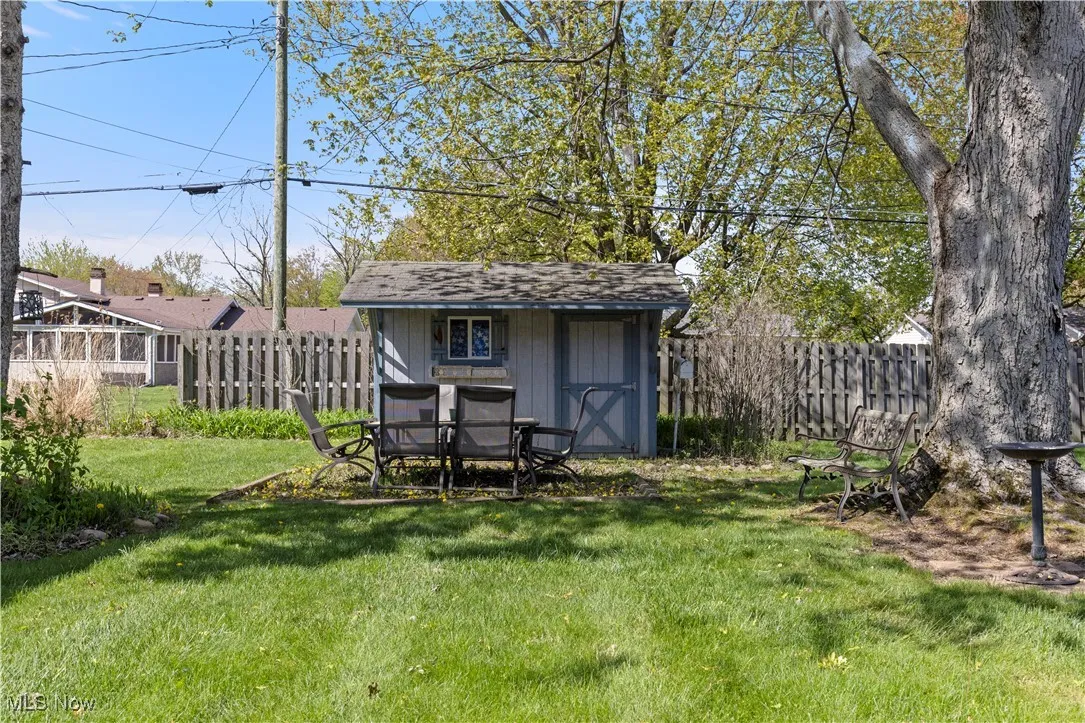 View of yard featuring a storage unit, fence, and an outdoor structure