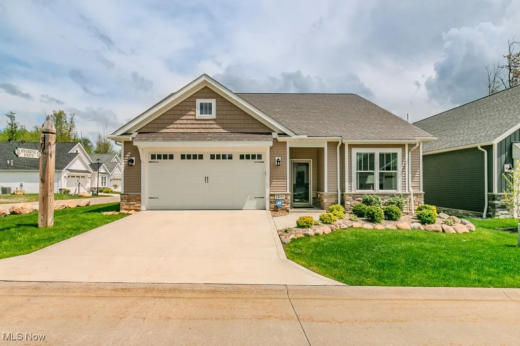 Craftsman inspired home with stone siding, driveway, a front yard, a garage, and a shingled roof