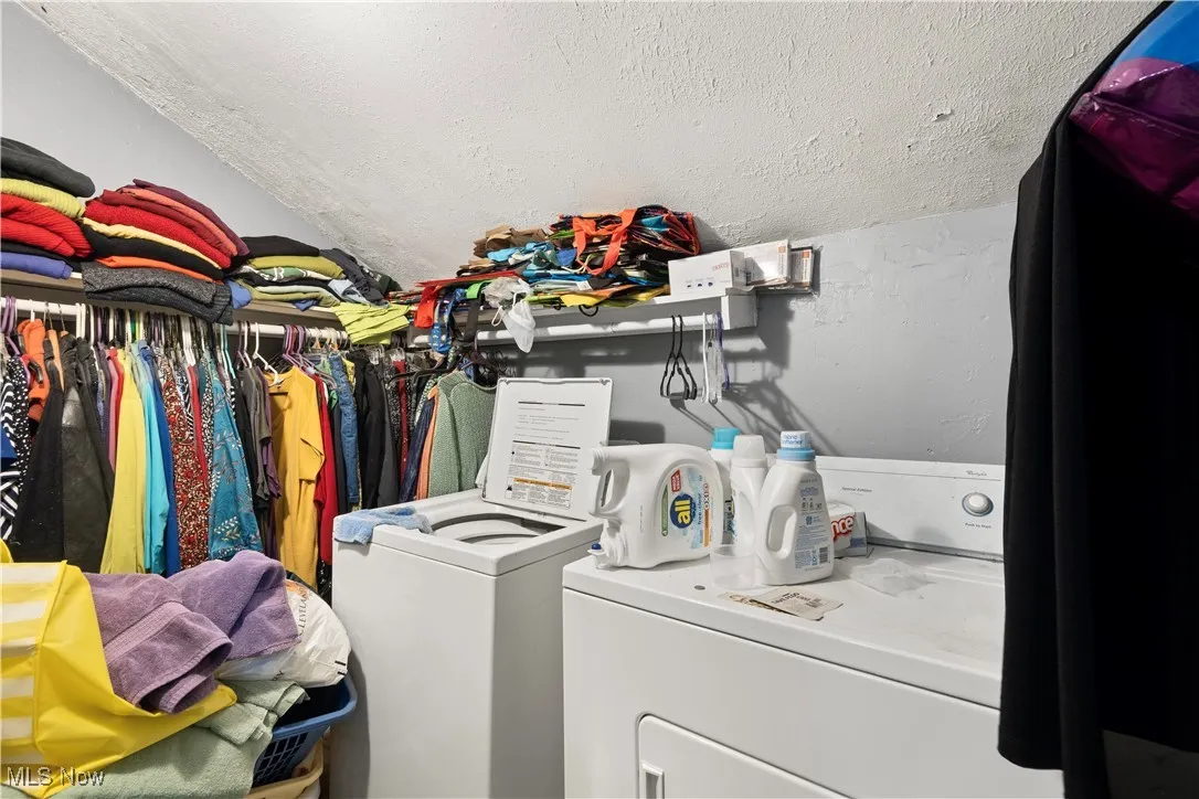 (Up unit laundry) Laundry area with independent washer and dryer and a textured ceiling