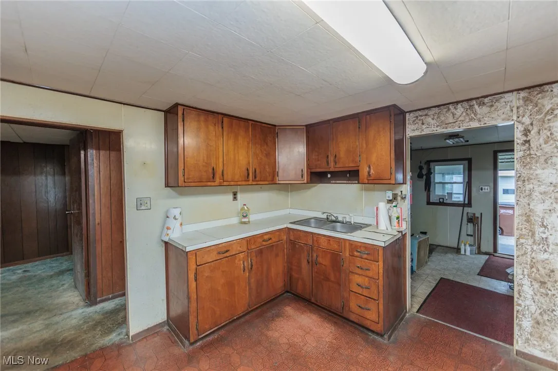 Kitchen featuring wooden walls and sink