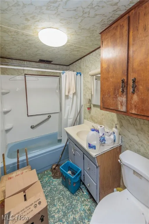 Full bathroom with vanity, toilet, and shower / bath combo with shower curtain